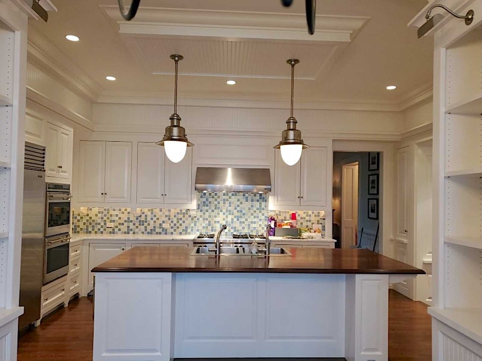 kitchen island painted white with two overhead light fixtures